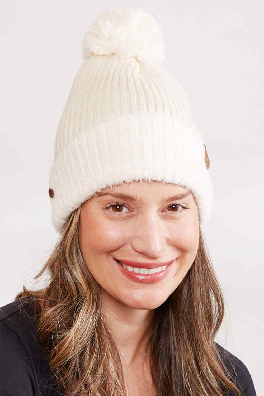 Beige Cozy up this season with our Ribbed Brim Button Pom Beanie, designed for warmth and style. Crafted from 100% acrylic, this soft knit hat features a classic ribbed texture, decorative buttons, and a charming pom pom on top.
