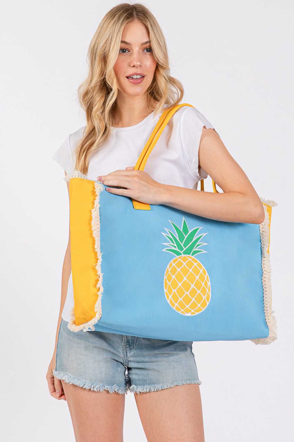 Blue Carry summer style with this vibrant pineapple embroidered tote. Crafted from durable 100% polyester, this spacious bag measures 17.5" x 14" x 5" and features a charming fringe design detail. The secure magnetic closure keeps your essentials safe, while an inner pocket adds convenient organization. Perfect for beach days, farmers markets, or everyday adventures. Made in China.