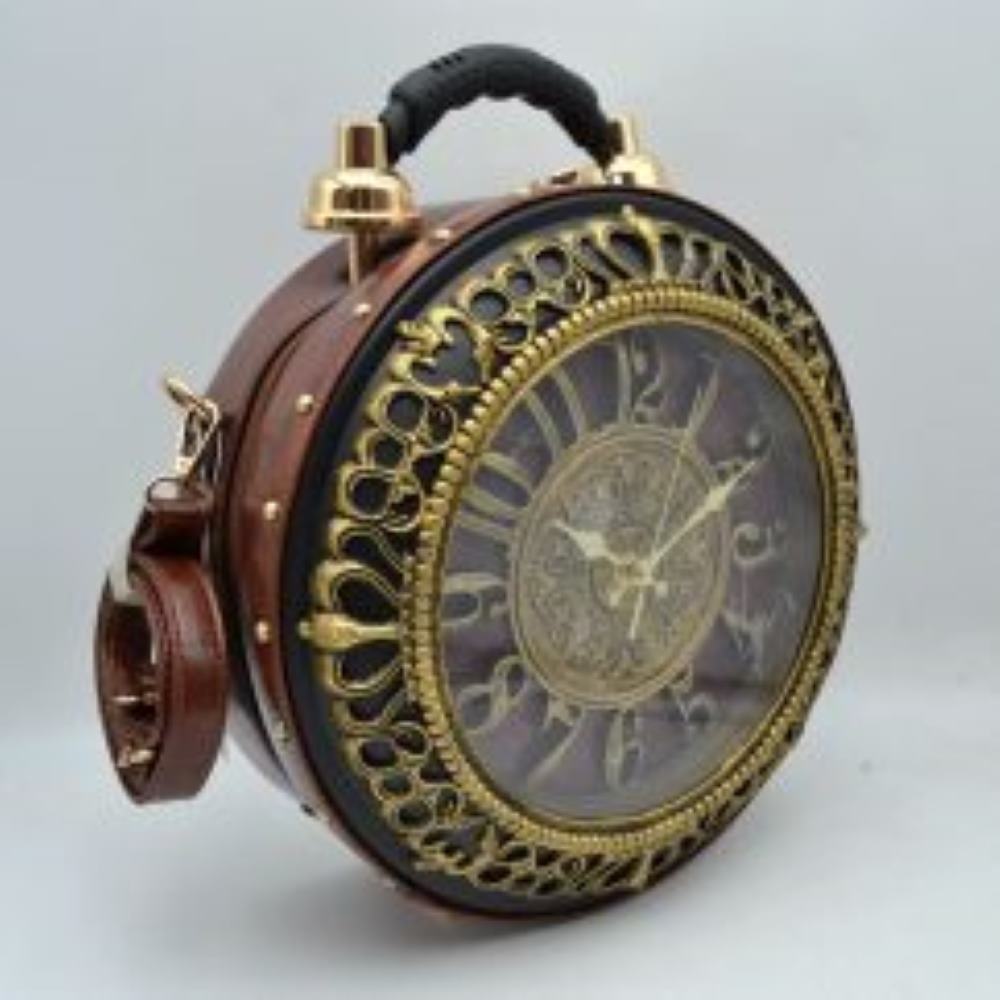 Brown This striking novelty handbag features a structured round silhouette inspired by a vintage twin-bell alarm clock, creating a dramatic statement piece with a distinct steampunk aesthetic. The large front panel showcases a highly detailed clock face with oversized numerals and classic gold-tone hands, beautifully framed by an intricate, baroque-style golden filigree border under a clear protective cover. Built with a rich brown faux-leather body accented by metallic studs