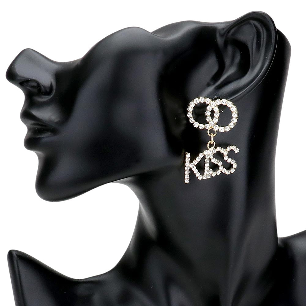 Gold KISS Rhinestone Embellished Message Dangle Earrings are the perfect accessory to add a touch of glamour to any outfit. The delicate dangle design adds movement and sparkle to your look, making you stand out from the crowd. Own these stunning earrings and shine like a star.