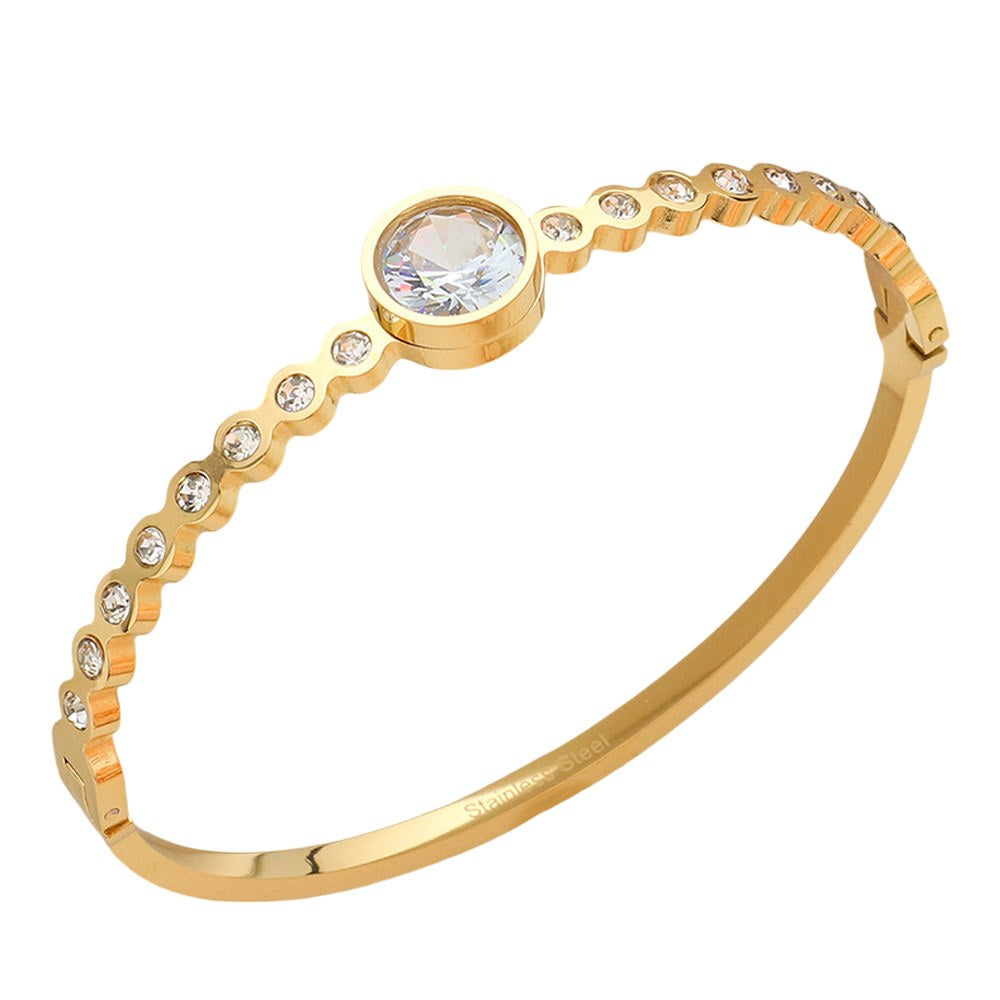 Gold Stainless Steel Round CZ Stone Bezel Hinged Bangle Bracelet. Made with high-quality stainless steel and featuring beautifully cut CZ stones in a bezel setting, this bangle adds a touch of elegance to any outfit. With a hinged design, it is easy to put on and take off for a comfortable fit. Elevate your style with this sophisticated accessory.