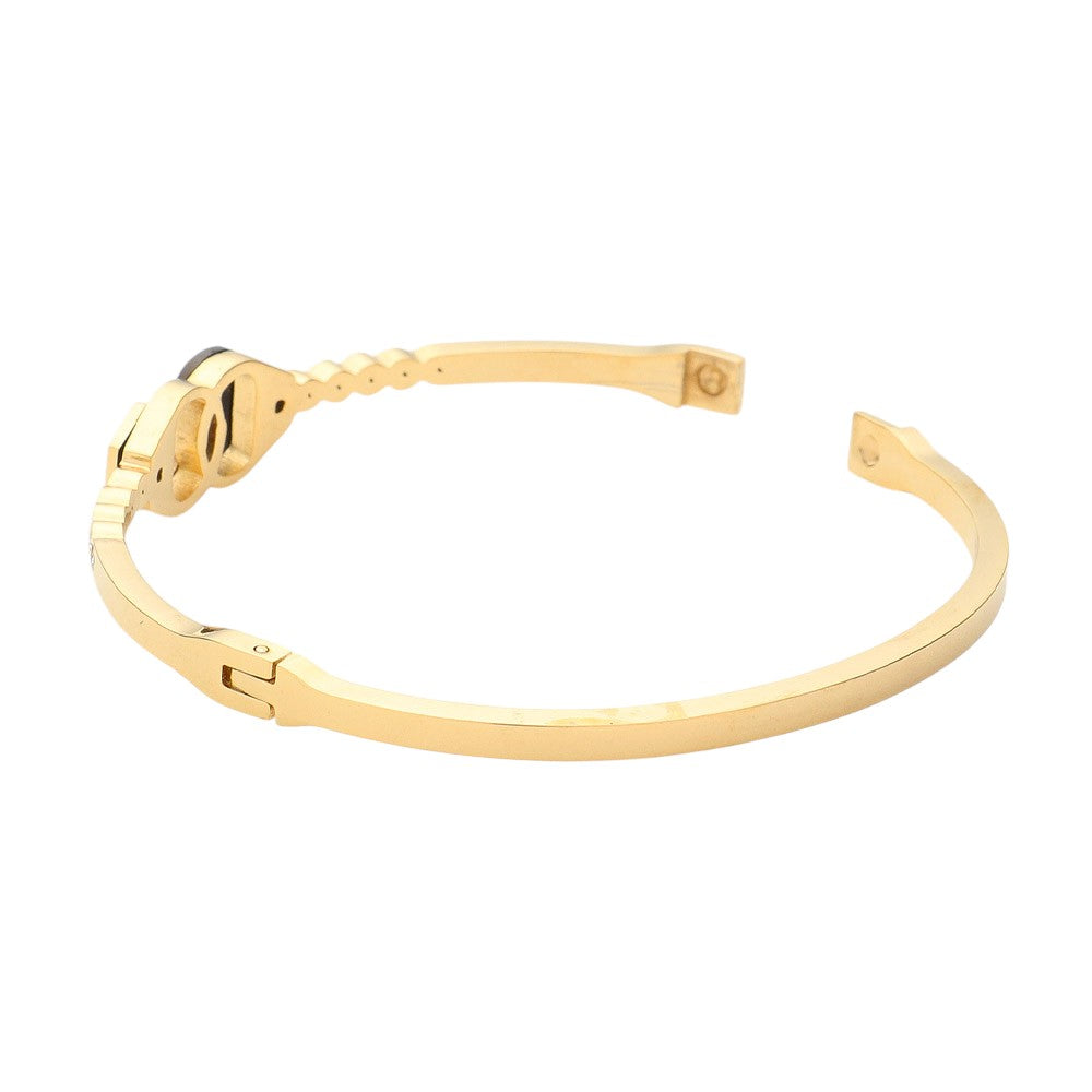 Gold Stainless Steel Stone Paved Handcuff Hinged Bangle Bracelet is the perfect combination of style and durability. Crafted with high-quality stainless steel and adorned with sparkling stones, this bracelet is sure to make a statement. The hinged design adds comfort and versatility. A must-have accessory for any fashion-forward individual.