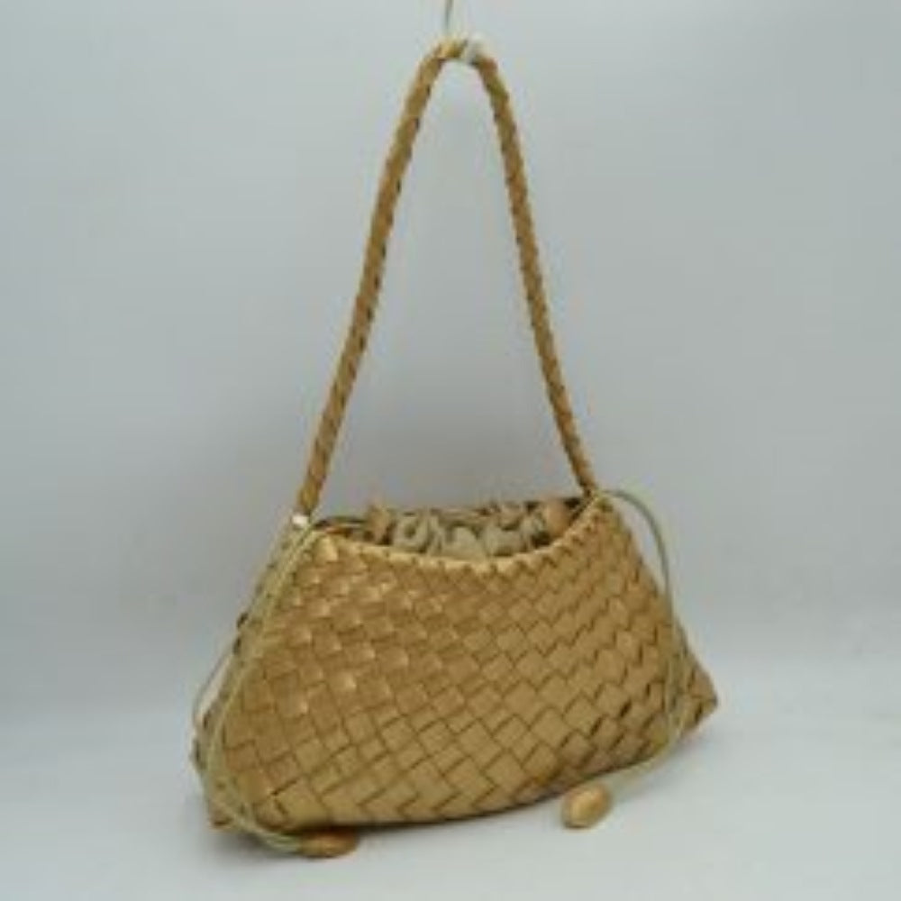 Gold This structural shoulder bag showcases an intricate woven pattern across its main body in a shimmering metallic gold tone, creating a highly textured and elegant silhouette. It features a single slim, braided shoulder strap attached securely to the upper corners for a comfortable drop. The main storage compartment is designed with an inner fabric lining that gathers tightly via a cinch drawstring closure, accented by long side cords finished with smooth