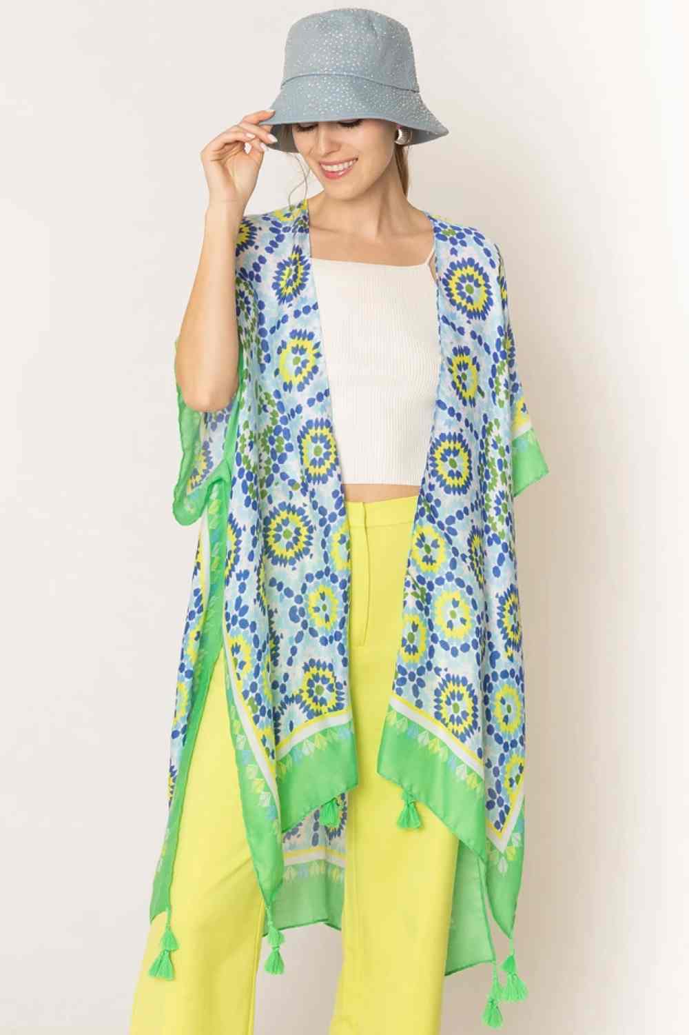 Green Effortless elegance meets bohemian charm with this stunning tile print kimono. Crafted from lightweight 100% polyester, this versatile piece features a captivating geometric tile pattern with contrasting stripe detailing along the edges and playful tassels for added movement and flair. Perfect for layering over any outfit, this kimono drapes beautifully at 35.4" x 35.4", making it ideal for beach days, casual outings, or relaxed evenings.