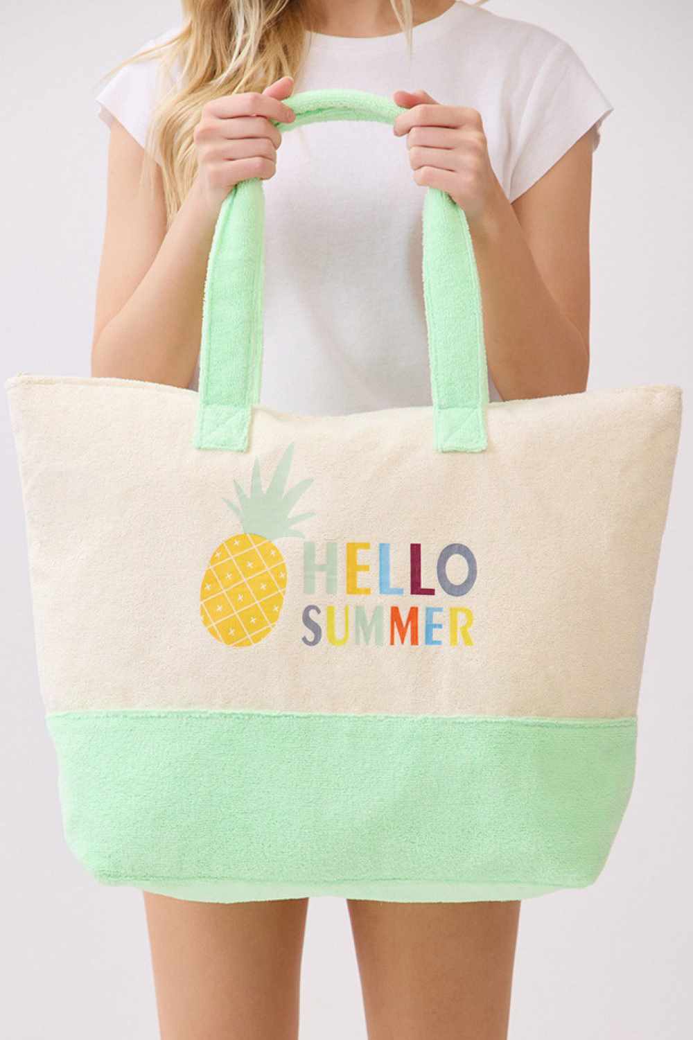MintGreen Brighten your days with this vibrant HELLO SUMMER tote bag, featuring playful multi-color lettering and cheerful pineapple design. Crafted from a durable polyester and polyamide blend, this spacious 22" x 16" x 6" bag is perfect for beach trips, shopping, or everyday adventures. The secure zipper closure keeps your essentials safe, while the convenient inner pocket adds extra organization. Lightweight and easy to carry, it's your go-to companion for sunny season style.