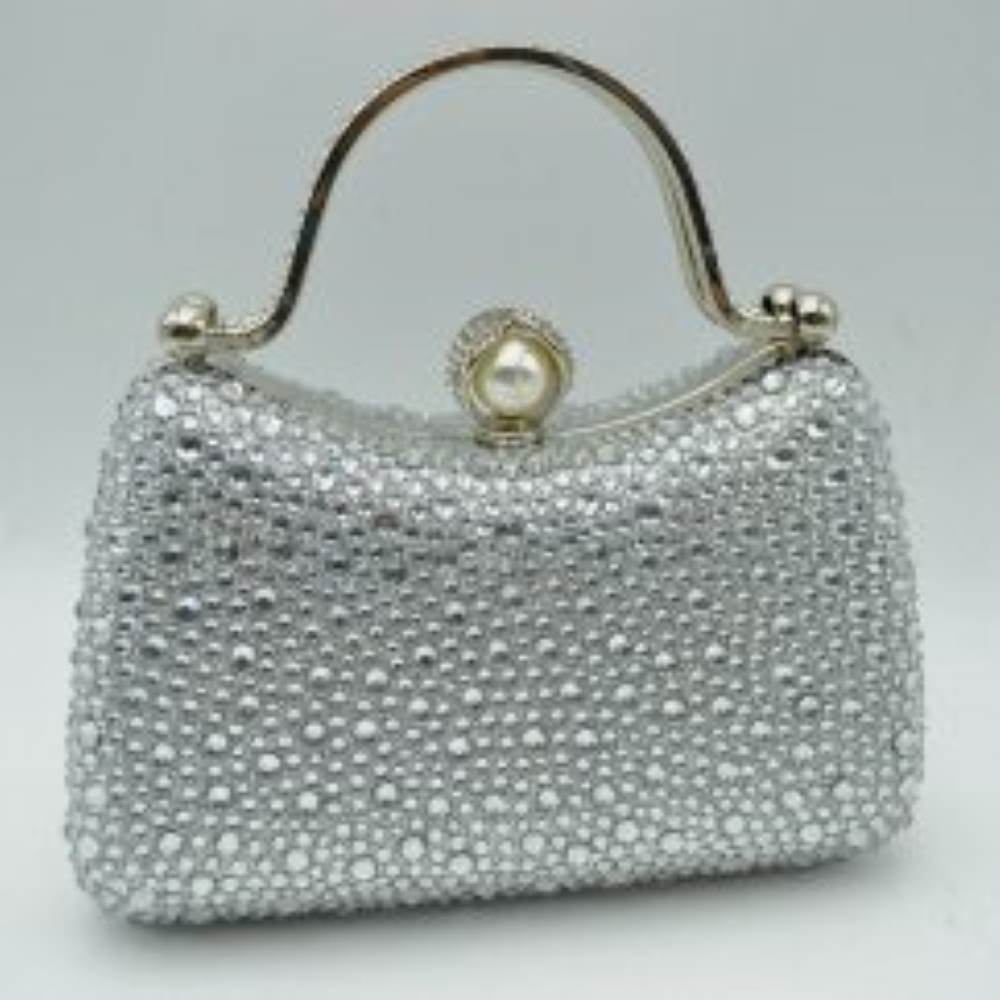 Silver This elegant evening clutch bag features a structured silhouette heavily encrusted with shimmering black rhinestones, offering a highly textured and glamorous look for formal events. A sleek, curved metallic top handle lined with delicate crystals rises over the frame for a secure grip, anchored by polished spherical accents. The secure metal frame is highlighted by a prominent decorative clasp featuring a large faux pearl wrapped in rhinestone-studded detailing