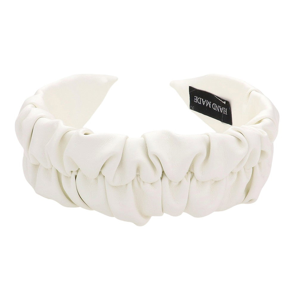 White Pleated Solid Faux Leather Headband, This stylish accessory adds an elegant touch to any outfit. Made with high-quality materials, it is both comfortable and durable. The pleated design offers a unique, sophisticated look, while the faux leather adds a touch of luxury. Perfect for any formal or casual occasion wear.