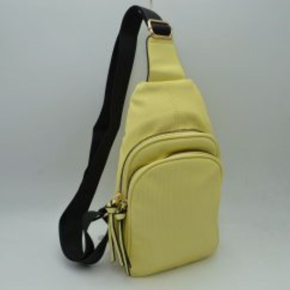 Yellow This practical sling bag features a textured, finely ribbed exterior w/ a tapered silhouette designed for comfortable everyday use. It offers organized storage compartments, including a curved main zippered section &a matching smaller front zippered pouch, both enhanced by elongated vertical tassel pulls hanging from the sliders. The bag is equipped w/ a single wide fabric shoulder strap attached to a smooth top panel & secured w/ a metallic adjustment buckle to easily customize the carrying length