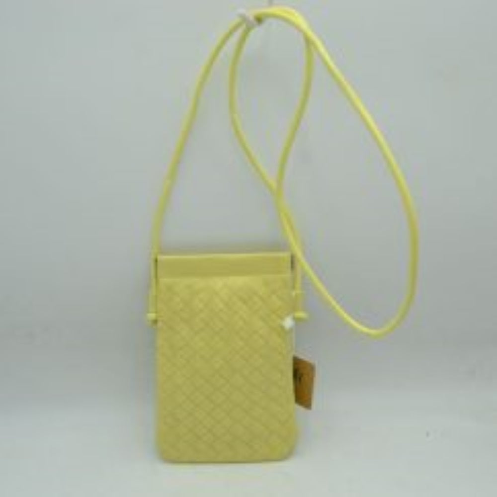 Yellow This compact vertical crossbody bag is designed for everyday functionality with a distinct woven textured pattern across its body. It features a slim, continuous cord strap attached securely to the sides with visible knot details for comfortable carrying. A clean horizontal opening at the top allows effortless access to the main storage compartment