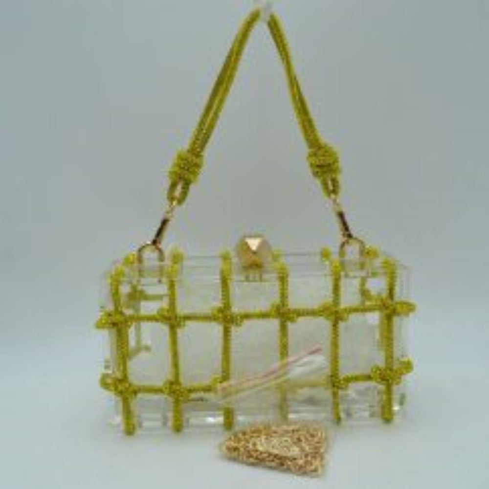 Yellow This unique everyday box clutch bag features a transparent structured body enclosed in a distinctive knotted cage overlay. Designed for specialized daily or evening use, the main storage compartment is secured by a top frame with a geometric metallic clasp closure. It offers versatile carrying options, equipped with a flexible cord top handle attached to the top panels via polished metal loops, alongside a separate metallic chain strap included at the base.