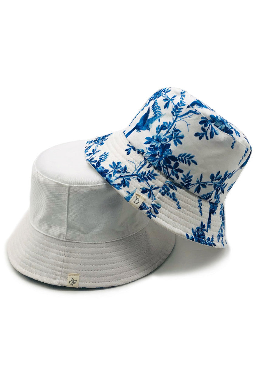 White ORIENTAL FLORAL BUCKET HAT features an authentic Oriental floral design, expertly rendered on premium fabric. The precision-crafted pattern draws inspiration from classical Eastern artistic traditions, while the structured silhouette offers reliable sun protection with a distinguished style. Its balanced proportions ensure a comfortable fit, making this a technically superior accessory that seamlessly integrates cultural artistry with practical functionality.