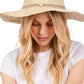 Beige Evil Eye braided band sun hat offers superior protection against harsh summer rays while maintaining breathability. The distinctive evil eye motif adds a sophisticated touch to casual outfits. Lightweight construction ensures comfort during extended wear, making it an essential accessory for beach outings, garden parties, or everyday sun protection.