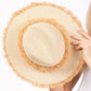 Beige Frayed Band and Trip Straw Sun Hat combines style and practicality. The frayed band adds a touch of texture, while the trip straw material provides superior sun protection. Perfect for a day at the beach or a stroll in the park, this hat will keep you both fashionable and protected.