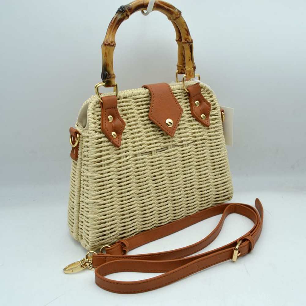 Beige This charming summer-inspired satchel bag features a structured woven straw body in a natural beige tone, paired with classic tan faux-leather accents. It is designed with a distinctive, polished bamboo top handle anchored by gold-toned hardware loops and riveted leather tabs. A central pointed faux-leather flap with a metallic snap button secures the main compartment opening.