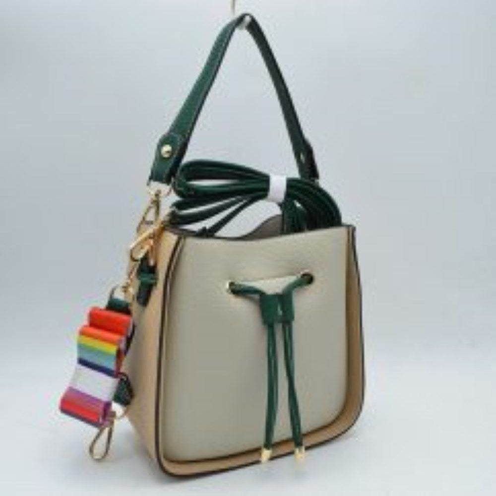 Beige This stylish bucket bag features a distinctive color-blocked design crafted with a pebbled exterior texture, making it a versatile accessory for everyday use. The front panel includes a classic cinch drawstring closure detailed with contrasting trim and polished metallic aglets that open to a secure main storage compartment. Built for flexibility, it is equipped with a structured shoulder handle, an adjustable long shoulder strap