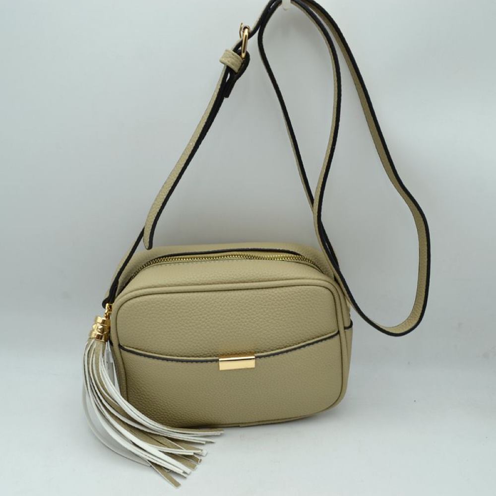 Beige This sophisticated crossbody bag features a structured camera-bag silhouette crafted from a textured pebbled faux leather in a neutral beige tone, making it a versatile addition to any wardrobe. The clean-lined front is detailed with a subtle open slip pocket highlighted by a polished, gold-tone metal hardware accent at the center. Secured by a smooth top-zipper closure, the bag is finished with an adjustable shoulder strap and a dramatic