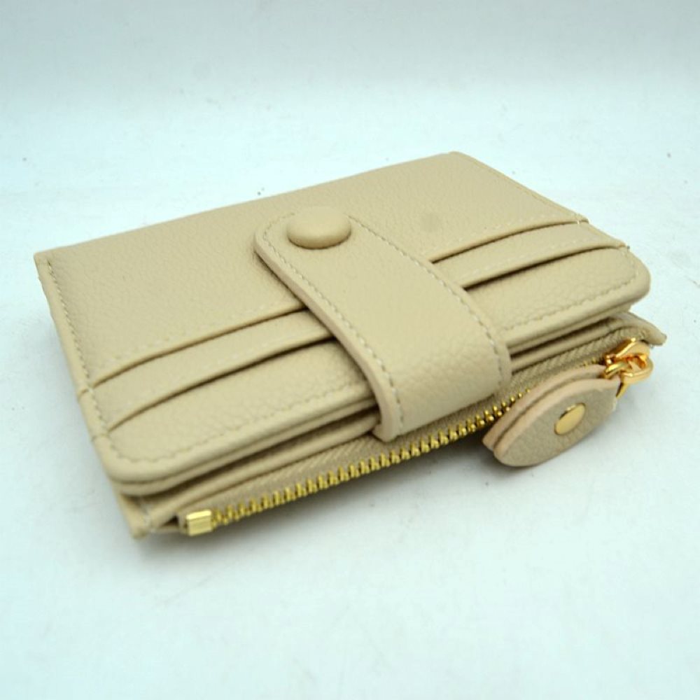Beige This compact card holder wallet features a textured pebbled exterior in a soft beige tone, providing a sleek and practical design for daily organization. The front panel is equipped with multiple exterior card slots secured by a matching leather strap with a snap button closure. A secure side pocket with a metallic gold-tone zipper and a detailed leather pull tab opens to an internal compartment for coins or folded bills, making it an essential companion for minimalist carrying.