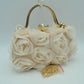Beige Make an elegant impression at your next formal event with this stunning evening clutch bag. The exterior features a beautiful arrangement of multi-dimensional, textured rosettes that create a soft floral pattern over a smooth base fabric. A polished, metallic top handle arches elegantly over the structured frame, while a prominent rhinestone-encrusted clasp closure sits at the top to secure your essentials with a touch of brilliant sparkle. Perfect for weddings, galas