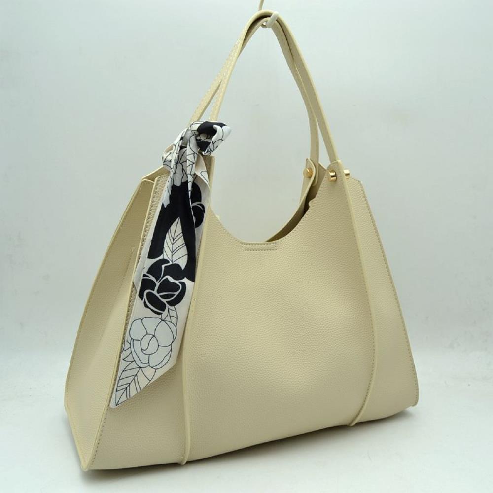 Beige Step out in effortless elegance with this beautifully structured shoulder tote bag, designed for the modern individual who values both style and functionality. Featuring a refined pebble-textured finish and a clean, sculptural silhouette, this handbag offers a sophisticated look that seamlessly transitions from office boardrooms to weekend outings. The bag is chicly accessorized with a removable black-and-white floral print scarf tied around the strap, adding a graceful, artistic flair.