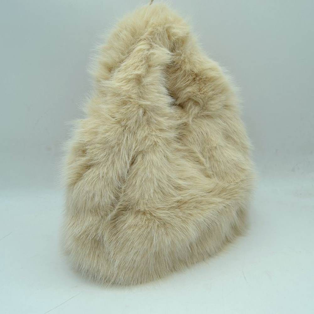 Beige This unique everyday handbag features an eye-catching, ultra-soft shaggy plush exterior that brings a cozy, tactile texture to your accessory collection. Designed with a rounded triangular silhouette, it includes an integrated top cutout handle woven seamlessly into the design for easy hand or wrist carrying. The top opening provides access to a central main storage compartment