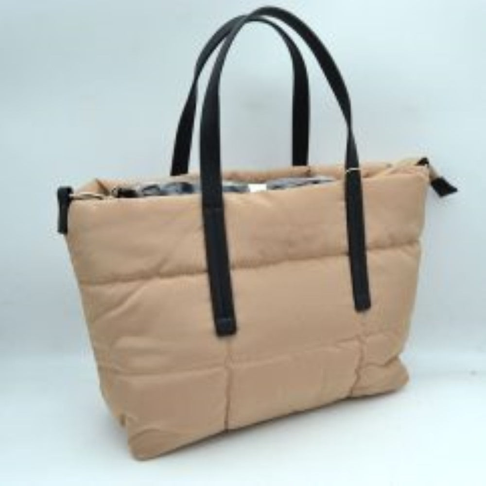 Beige This cozy tote bag features a soft, padded puffer exterior with a unique quilted grid pattern, making it a practical and stylish choice for casual everyday use. The warm tan silhouette is contrasted by sleek, flat black dual top handles stitched securely to the front and back panels for a comfortable carry. It is equipped with a secure top zipper closure to keep all your daily essentials safe, along with side attachment rings to accommodate an optional shoulder strap.