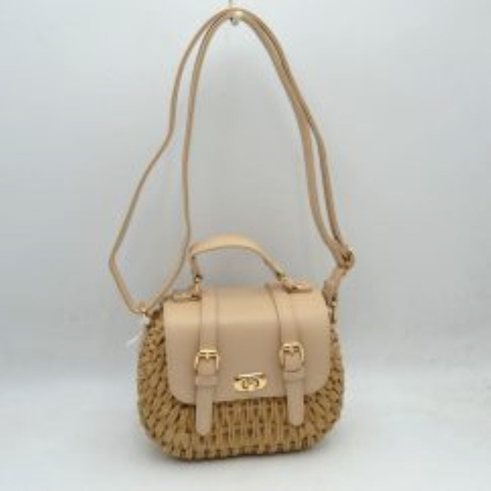 Beige This charming satchel features a woven straw body paired with a smooth faux leather foldover flap, making it a stylish choice for warm-weather outings. It is detailed with dual decorative buckle straps on the front along with a secure gold-tone turn-lock closure. Designed for versatile wear, it includes a sturdy top handle for handheld carrying and a long, adjustable shoulder strap for comfortable hands-free crossbody or shoulder styling.