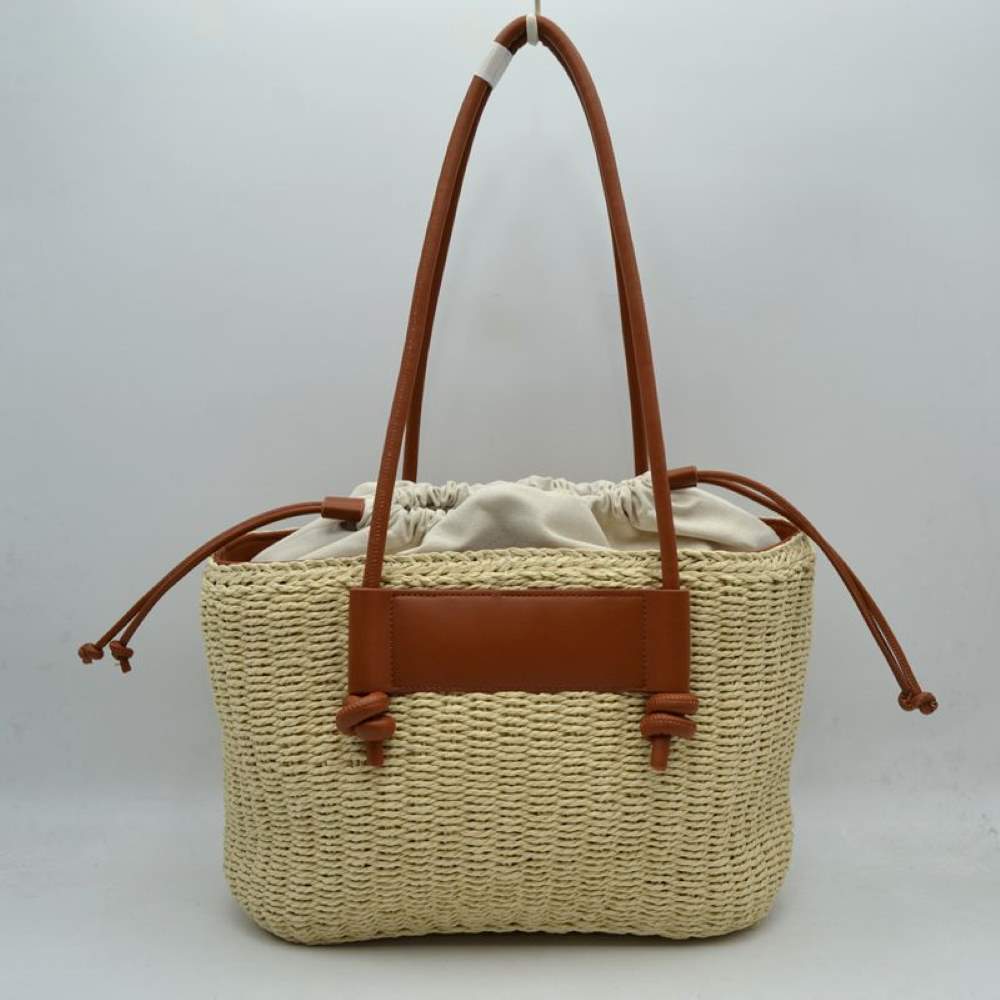 Beige Capture the ultimate warm-weather aesthetic with this gorgeous woven straw market tote. Perfectly blending a relaxed, organic texture with contemporary faux-leather accents, this shoulder bag is your ideal companion for beach getaways, local farmers' markets, or sunny vacation strolls.