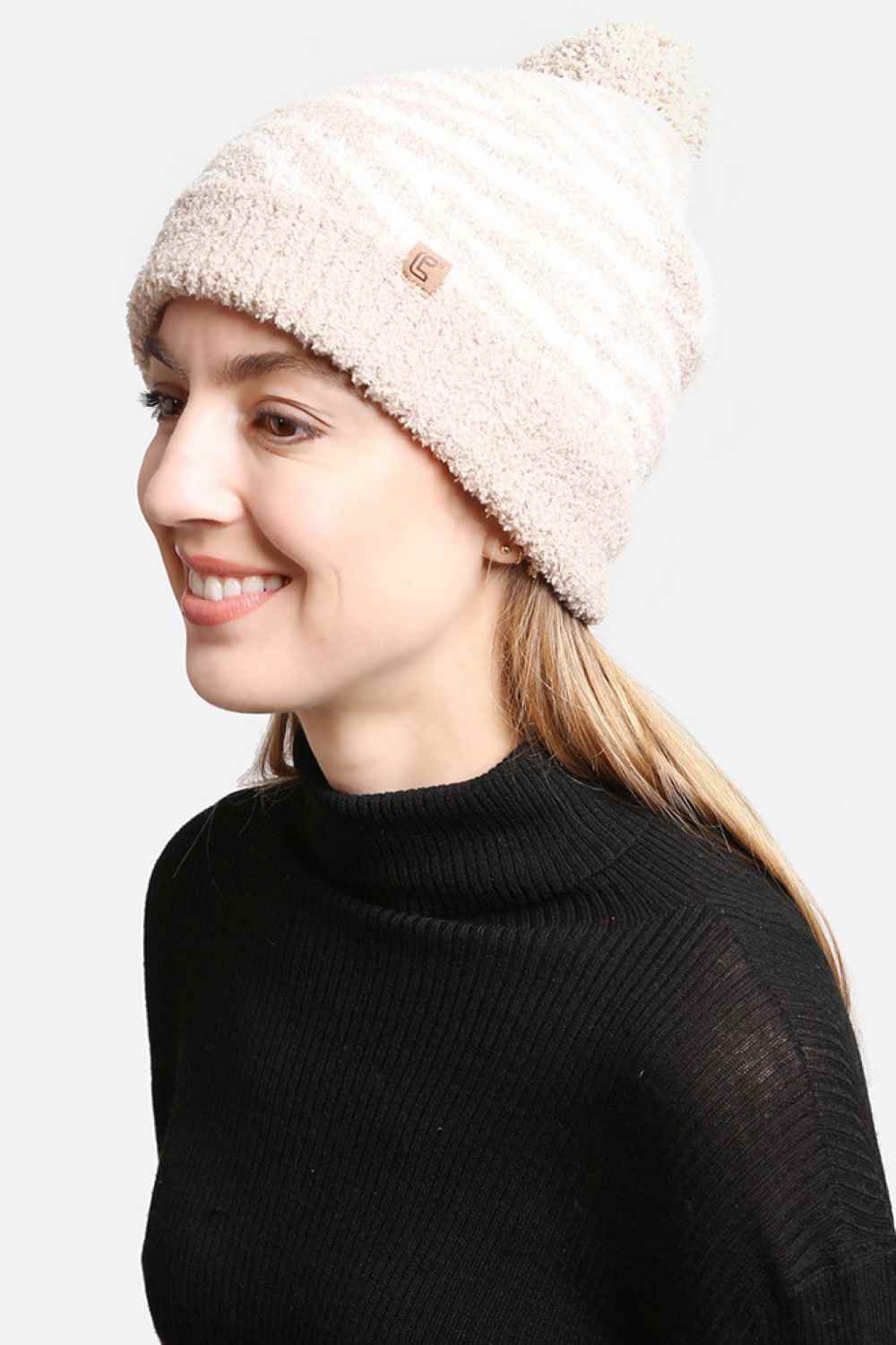 Beige The Zebra Knit Pom Pom Lining Beanie features a bold zebra pattern that adds a fun, statement look to your winter outfit. Designed with a soft inner lining and a fluffy pom pom detail, it provides extra warmth, comfort, and a secure fit on cold days.