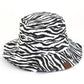 Black C.C. ZEBRA PRINT BUCKET HAT is the perfect accessory for any outdoor adventure. Made from high-quality materials, it offers both style and functionality. Stay protected from the sun and make a statement with its bold zebra print design. Trust in C.C. for expertly crafted hats.