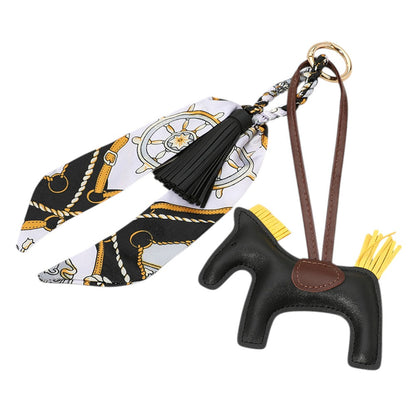 Black Faux Leather Horse Tassel Scarf Bag Charm. Made with high-quality faux leather, this elegant charm is designed to add a touch of sophistication to your favourite bag. The intricate horse design and tassel detail make it a unique accessory that will surely elevate your style.
