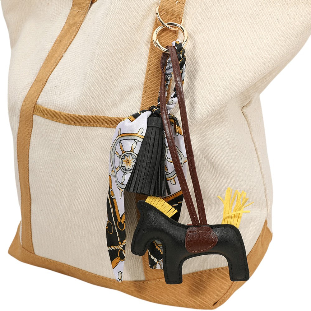 Black Faux Leather Horse Tassel Scarf Bag Charm. Made with high-quality faux leather, this elegant charm is designed to add a touch of sophistication to your favourite bag. The intricate horse design and tassel detail make it a unique accessory that will surely elevate your style.
