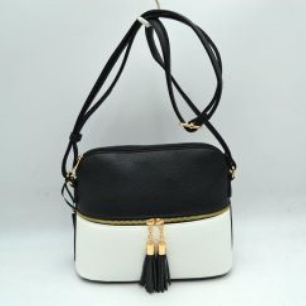 Black This everyday crossbody bag features a structured pebbled texture body with a distinct two-toned paneled design. Ideal for organized daily use, it showcases a prominent horizontal front zipper with dual gold-toned pulls, each adorned with a decorative hanging fringe tassel. The main storage compartment is paired with a matching long