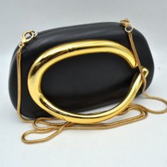 Black This structured, hard shell clutch bag functions as an elegant accessory for everyday use or special occasions, featuring a smooth matte surface. A large, prominent metallic ring handle anchors the front design, offering a secure hand-held grip. For alternative carrying styles, the bag is equipped with a detachable metallic snake chain strap that secures to the top corners with lobster claw clasps, providing functional storage in a compact, rigid silhouette.