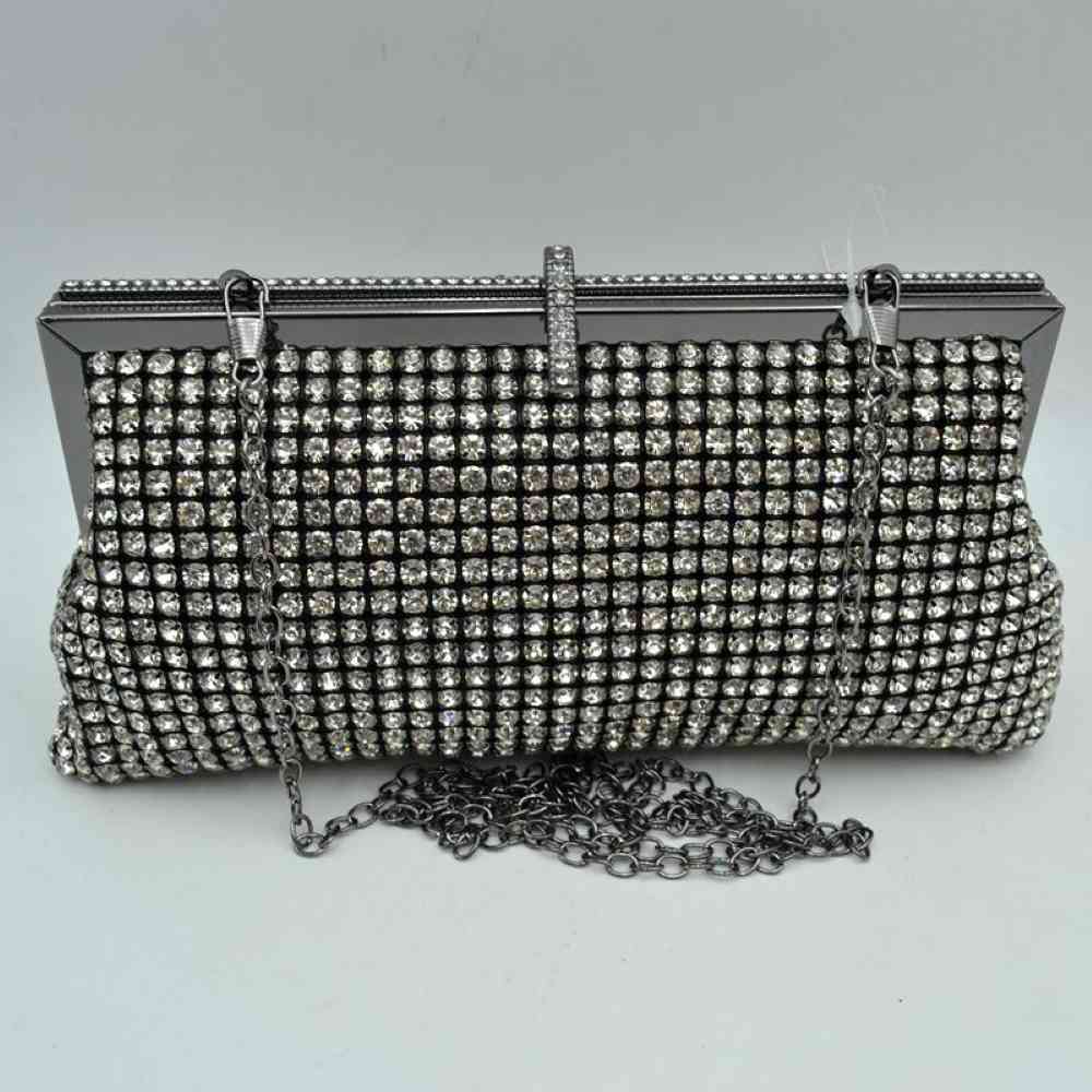 Black Add a touch of glamour to your next special occasion with this exquisite evening clutch bag. Designed to catch the light from every angle, this handbag features a fully embellished exterior lined with rows of shimmering crystal rhinestones and a distinctive, rhinestone-accented top clasp closure that adds an extra layer of elegance while keeping your essentials secure. Perfect for weddings, galas, parties, or formal events