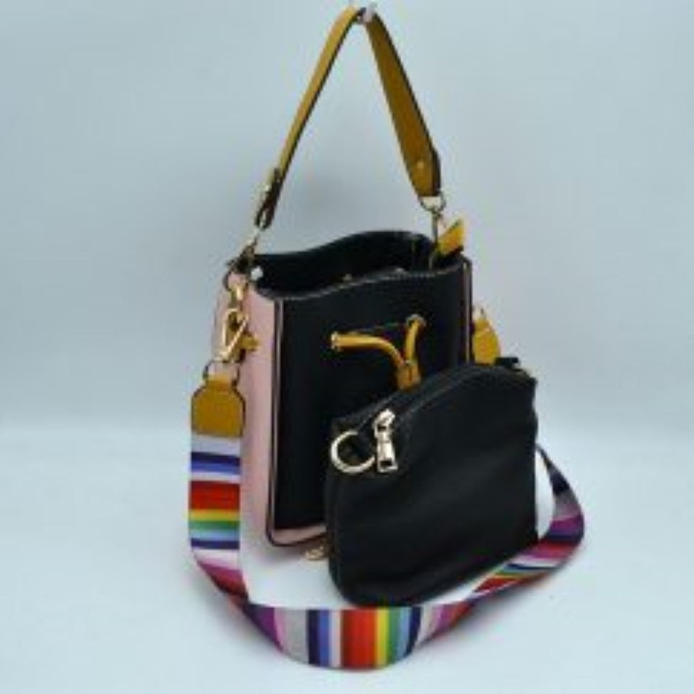 Black This stylish bucket bag features a distinctive color-blocked design crafted with a pebbled exterior texture, making it a versatile accessory for everyday use. The front panel includes a classic cinch drawstring closure detailed with contrasting trim and polished metallic aglets that open to a secure main storage compartment. Built for flexibility, it is equipped with a structured shoulder handle, an adjustable long shoulder strap