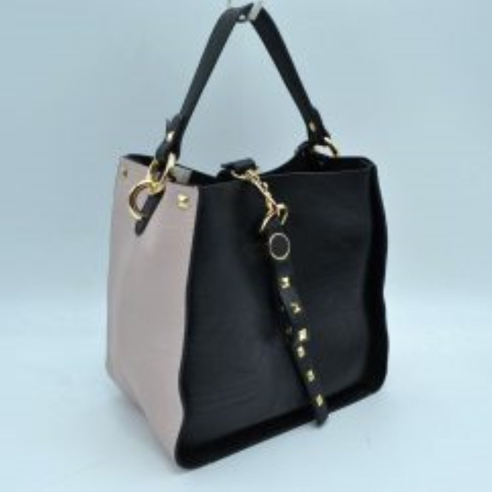 Black This versatile handbag features a structured, two-tone design accented with square studs along the upper corners and on a decorative hanging strap. Perfect for everyday use, the bag offers an open top main compartment to easily store and access daily essentials. A flat top handle connected via rounded hardware rings provides a convenient carrying option, blending practical utility with contemporary style.