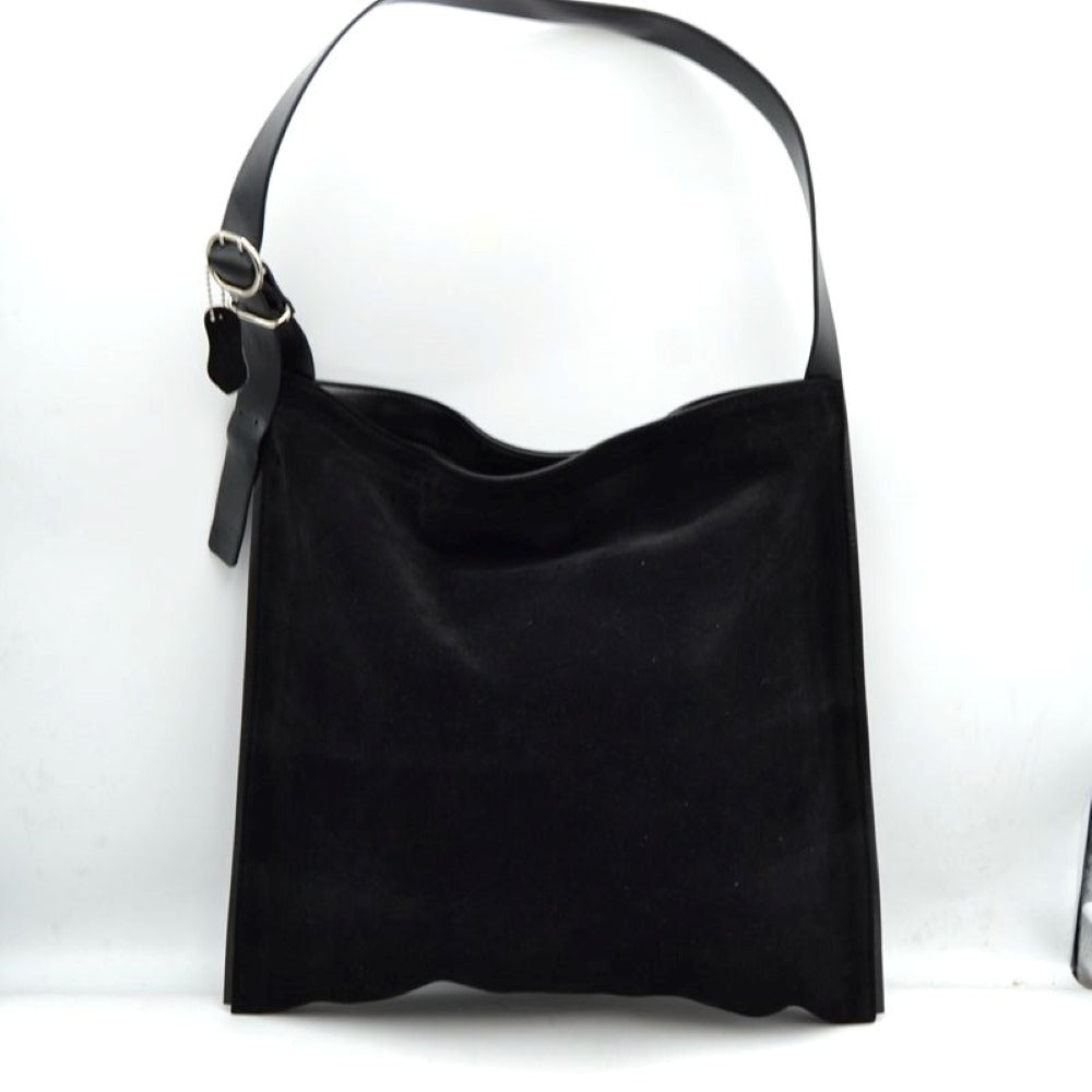 Black This slouchy hobo bag features a clean, soft-textured exterior with a relaxed, square-shaped silhouette that makes it ideal for everyday use. Designed with a spacious main compartment to easily organize and store daily essentials, the bag is equipped with a wide, flat shoulder strap for comfortable carrying. The single strap includes a metallic buckle closure system on one side, allowing for functional adjustments while adding a touch of classic detail to the overall minimalist design.
