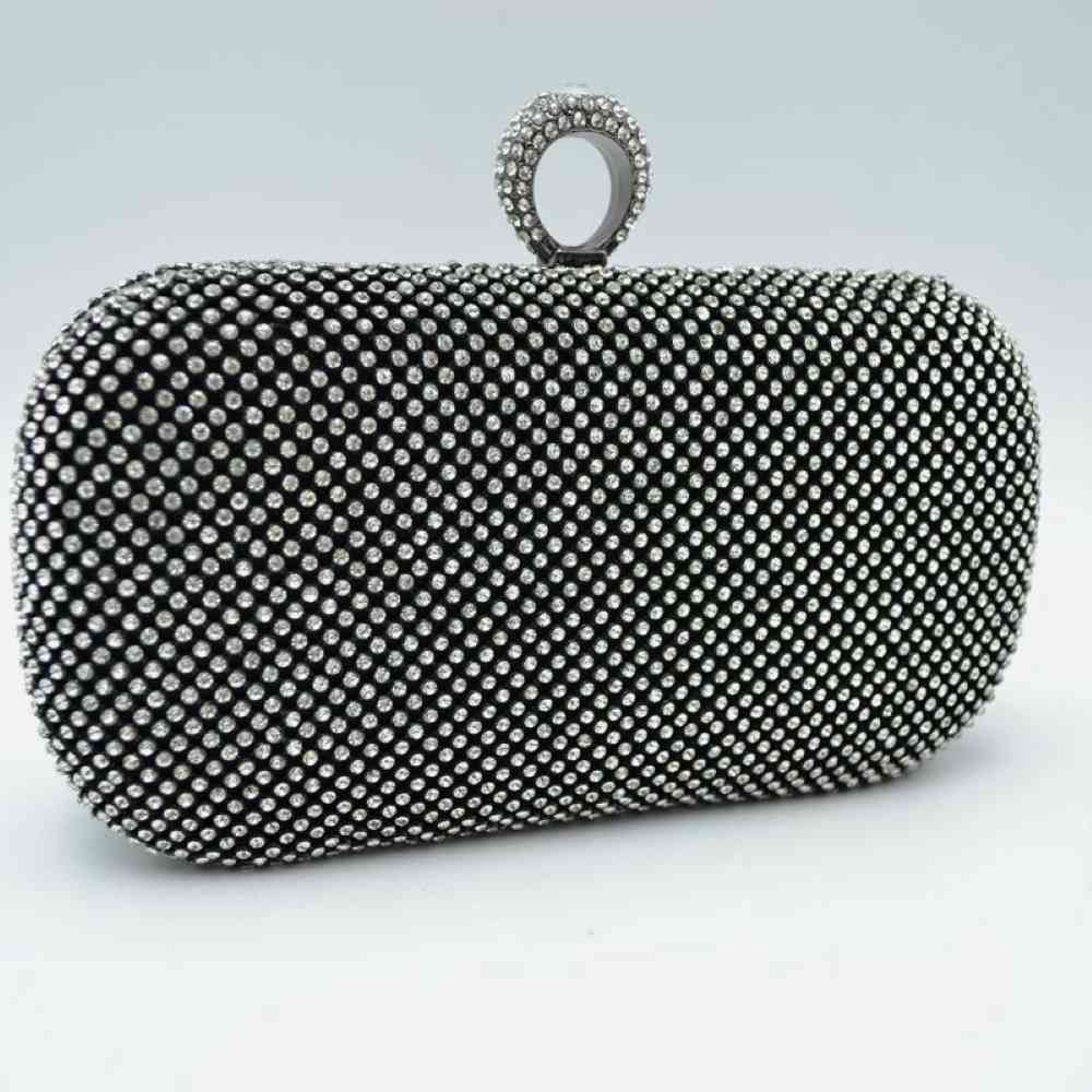 Black This hard-case box clutch features a fully embellished grid pattern of shimmering studs, offering an eye-catching accent suitable for elevated everyday use or special occasions. The rigid, rounded silhouette encloses a main storage compartment designed to keep essentials secure. It is topped with a decorative, textured ring clasp that serves as both a distinct top handle element and a functional closure mechanism mechanism to open the bag.