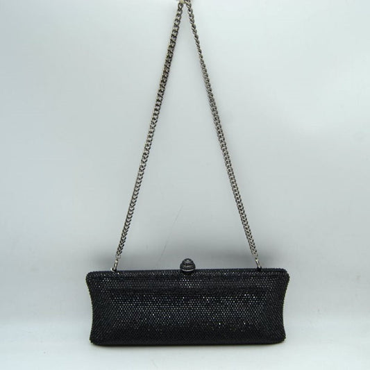 Black This structured clutch bag features an elongated silhouette with subtly flared edges, completely covered in fine, glittering micro-embellishments that create a shimmering, textured surface suitable for elegant everyday use. The central storage compartment is securely accessed via a hard-frame opening with an ornamental, rounded top clasp. A long, slender metallic curb chain strap is permanently attached to the top loops