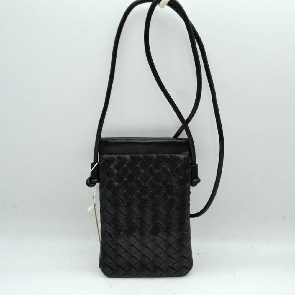 Black This compact vertical crossbody bag is designed for everyday functionality with a distinct woven textured pattern across its body. It features a slim, continuous cord strap attached securely to the sides with visible knot details for comfortable carrying. A clean horizontal opening at the top allows effortless access to the main storage compartment