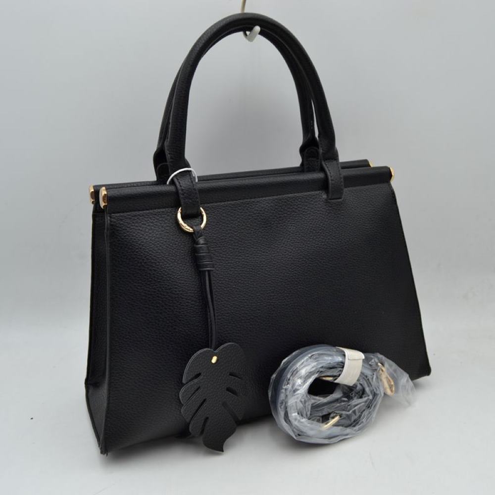 Black This stylish structured handbag is designed for everyday elegance and practicality. Crafted with a premium textured finish, it features a sleek top-handle design with gold-tone hardware accents for a luxurious touch. The spacious interior provides enough room for daily essentials like phone, wallet, cosmetics, and small accessories, making it perfect for both office and casual use. It also comes with a detachable and adjustable shoulder strap for versatile carrying options.