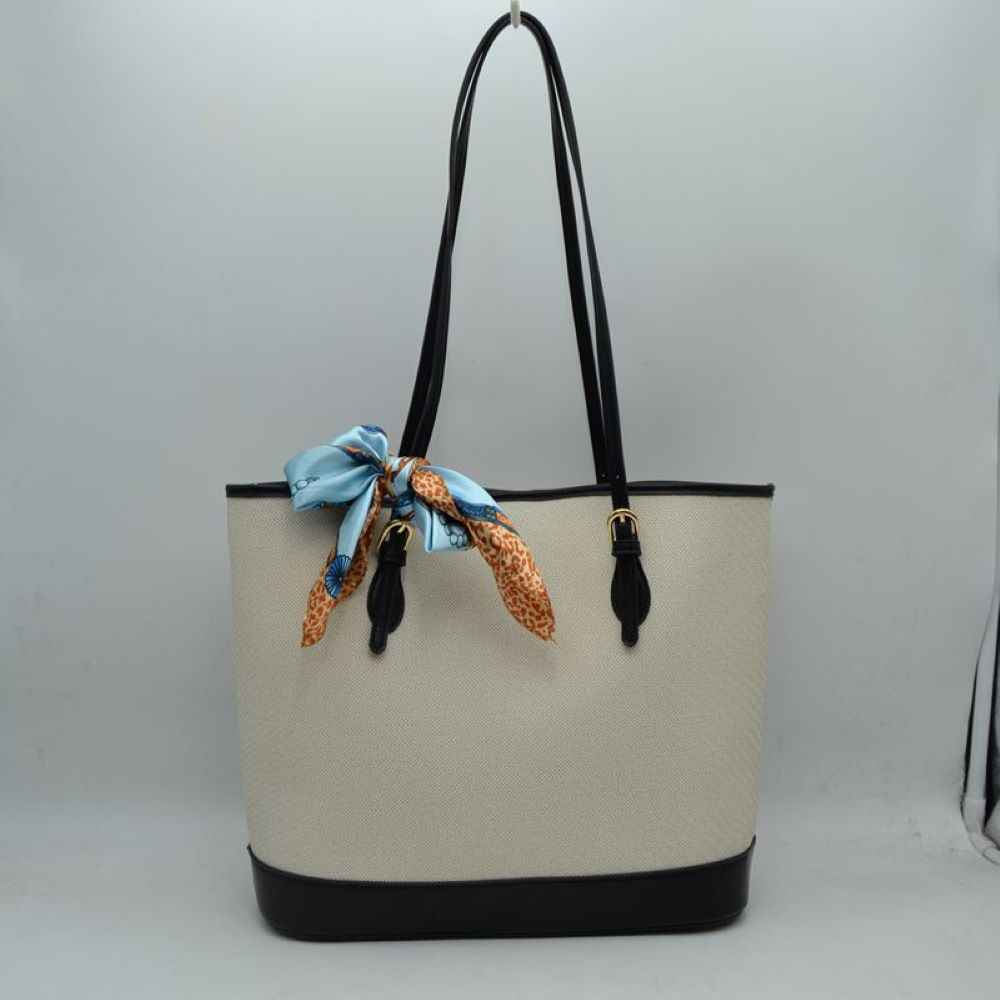Black Step out in style with this sophisticated and timeless tote bag. Designed with an understated chevron-style textured weave, this bag seamlessly blends classic elegance with everyday functionality. Perfect for work, travel, or upscale weekend outings, it comes complete with a vibrant, playful silk-style scarf wrapped around the handle for an instant touch of Parisian chic.