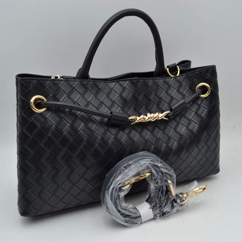 Black Make a sophisticated statement wherever you go with this elegantly structured woven tote bag. Featuring a distinctive diagonal checkerboard weave pattern, this handbag brings a touch of modern luxury and rich texture to any wardrobe. The front is beautifully accented with a unique metallic centerpiece detail threaded through polished grommets, adding a contemporary twist to a classic silhouette. Designed for maximum versatility, it features comfortable dual top handles alongside a wrapped