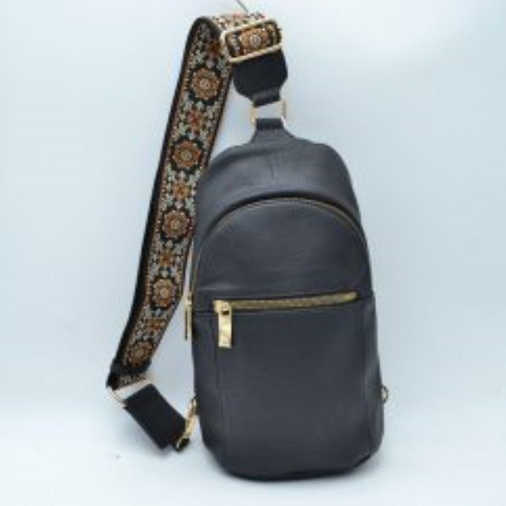 Black This functional sling bag features a contoured silhouette designed for comfortable everyday use and hands-free convenience. It offers multiple storage compartments, including a spacious main zippered section and an easily accessible front zippered pocket equipped w/ a metallic pull tab. The wide, adjustable shoulder strap showcases an intricate, repeating floral woven pattern and features a metallic slide buckle for a customizable fit across the body, connecting securely w/ durable metal hardware.