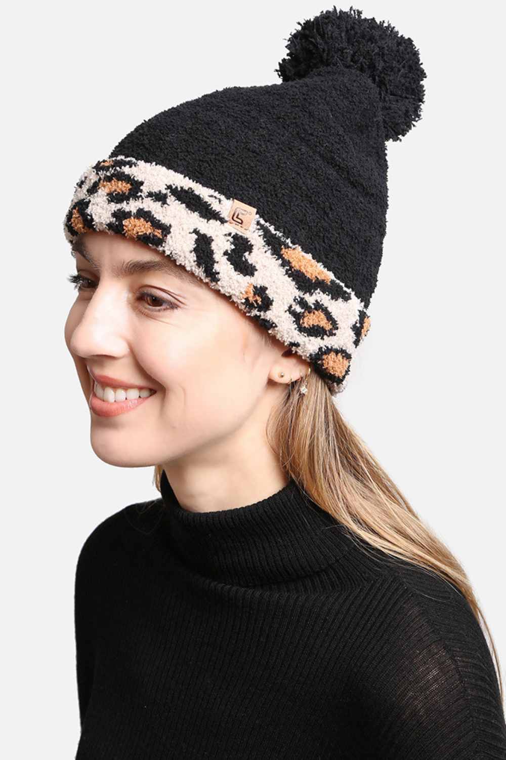 Black The Leopard Cuffed Pom Pom Lining Beanie features a trendy animal print design with a stylish cuffed finish for a bold winter look. Crafted with a soft inner lining and topped with a fluffy pom pom, it delivers extra warmth, comfort, and a snug fit for chilly days.
