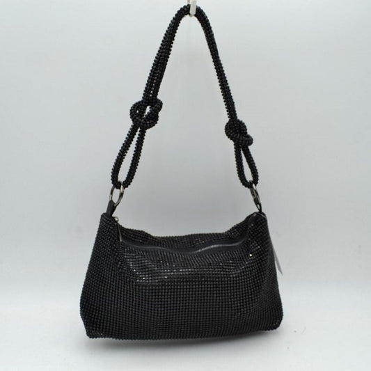 Black This shoulder bag features a textured grid exterior suitable for versatile everyday use. It includes a main storage compartment accessible via a top zipper closure to keep personal items secure. The bag is completed by a matching textured shoulder strap that features integrated decorative knots on each side and connects to the main body through circular rings.
