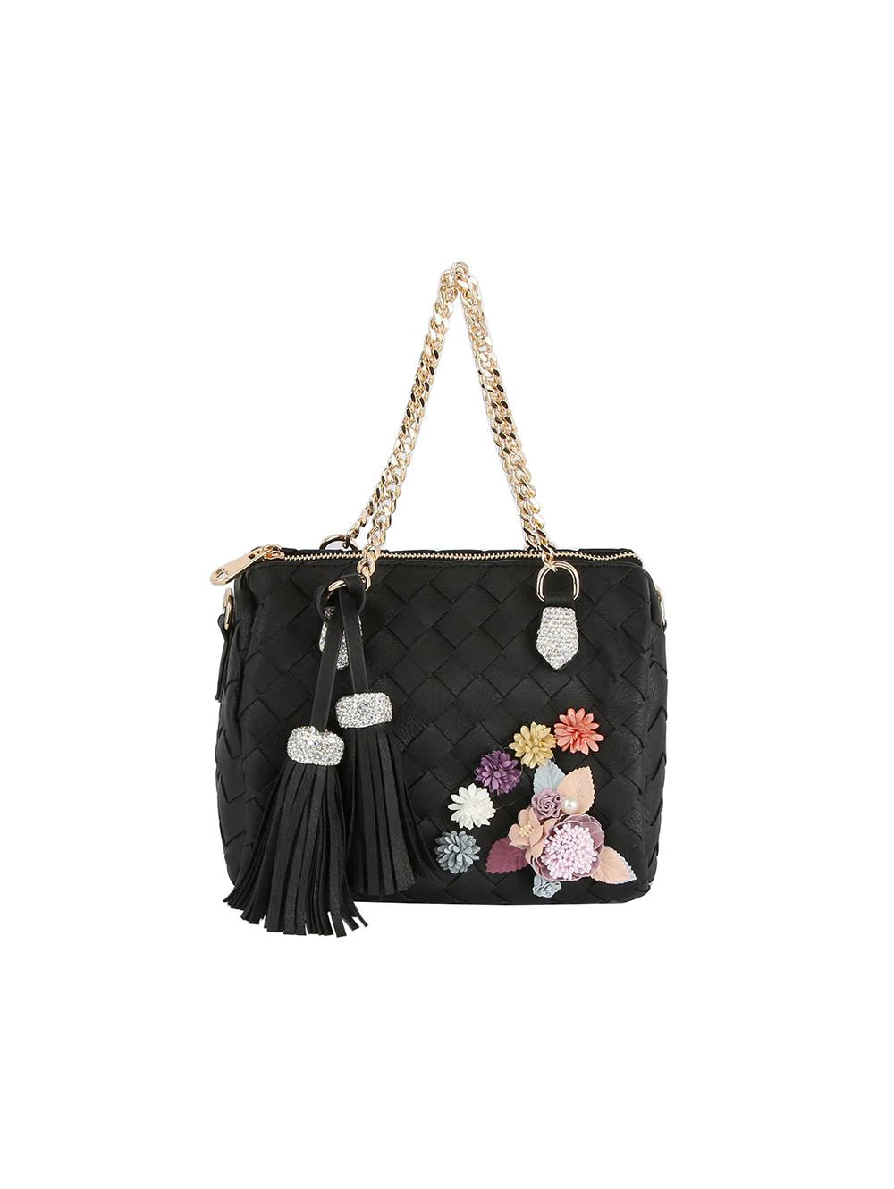Black This structured shoulder bag features a quilted diamond pattern across the exterior, enhanced by an arrangement of dimensional floral accents on the front panel. Designed with dual woven chain handles that secure to metallic hardware loops, it offers an elegant option for everyday use or special occasions. A secure top zipper closure opens to the main storage compartment, which is stylishly accessorized with two large hanging tassels attached to the side handle base.