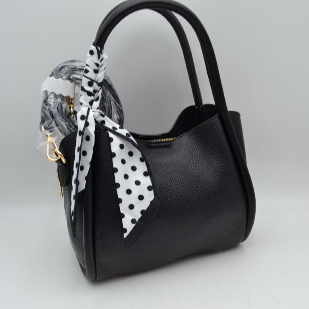 Black Add a touch of retro sophistication to your everyday look with this beautifully contoured satchel handbag. Designed with a structured yet softly curved silhouette, this bag features a premium pebble-textured finish that resists daily wear while maintaining a polished aesthetic. The side handle is playfully wrapped with a removable black-and-white polka dot scarf, lending a timeless, feminine charm to the overall piece.