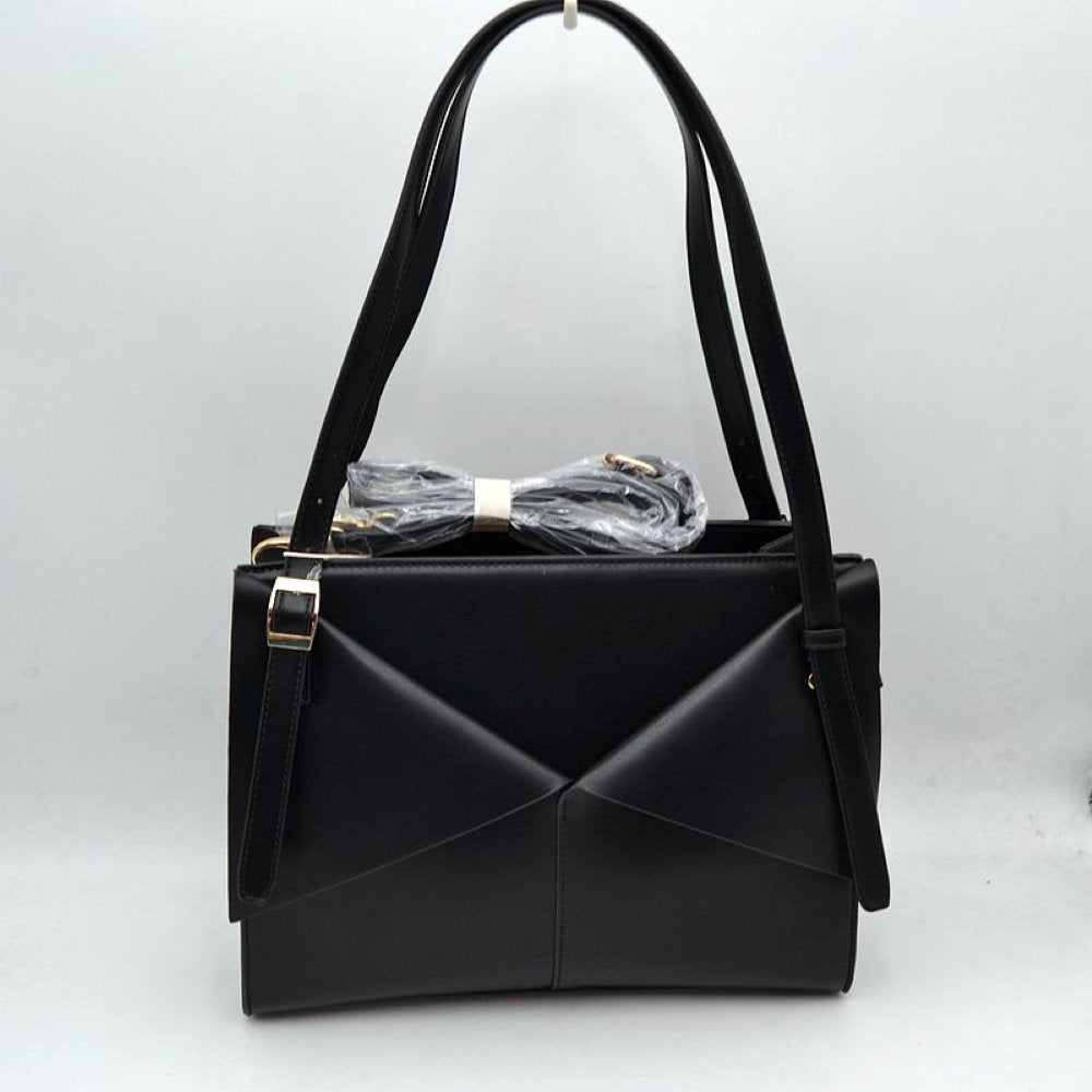 Black Make a sharp, modern impression with this beautifully architectural rectangular tote bag. Defined by its unique front panel detailing, it features overlapping angled overlays that mimic the sleek lines of a classic envelope flap. Crafted with a smooth matte finish and a highly structured silhouette, this handbag sits securely upright on a flat base, maintaining its clean lines all day long. It comes equipped with extra-long, adjustable top handles for comfortable over-the-shoulder wear
