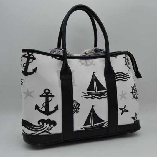 Black Set sail with this nautical-inspired canvas tote. Featuring a crisp backdrop decorated with a classic print of anchors, sailboats, ship wheels, and ocean waves, this bag is the perfect accessory for coastal getaways or adding maritime flair to your daily ensemble. Framed with structured textured trim, it balances casual resort style with sharp, everyday functionality. 
